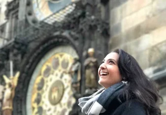 Girl standing by astronomical clock in Prague Old Town